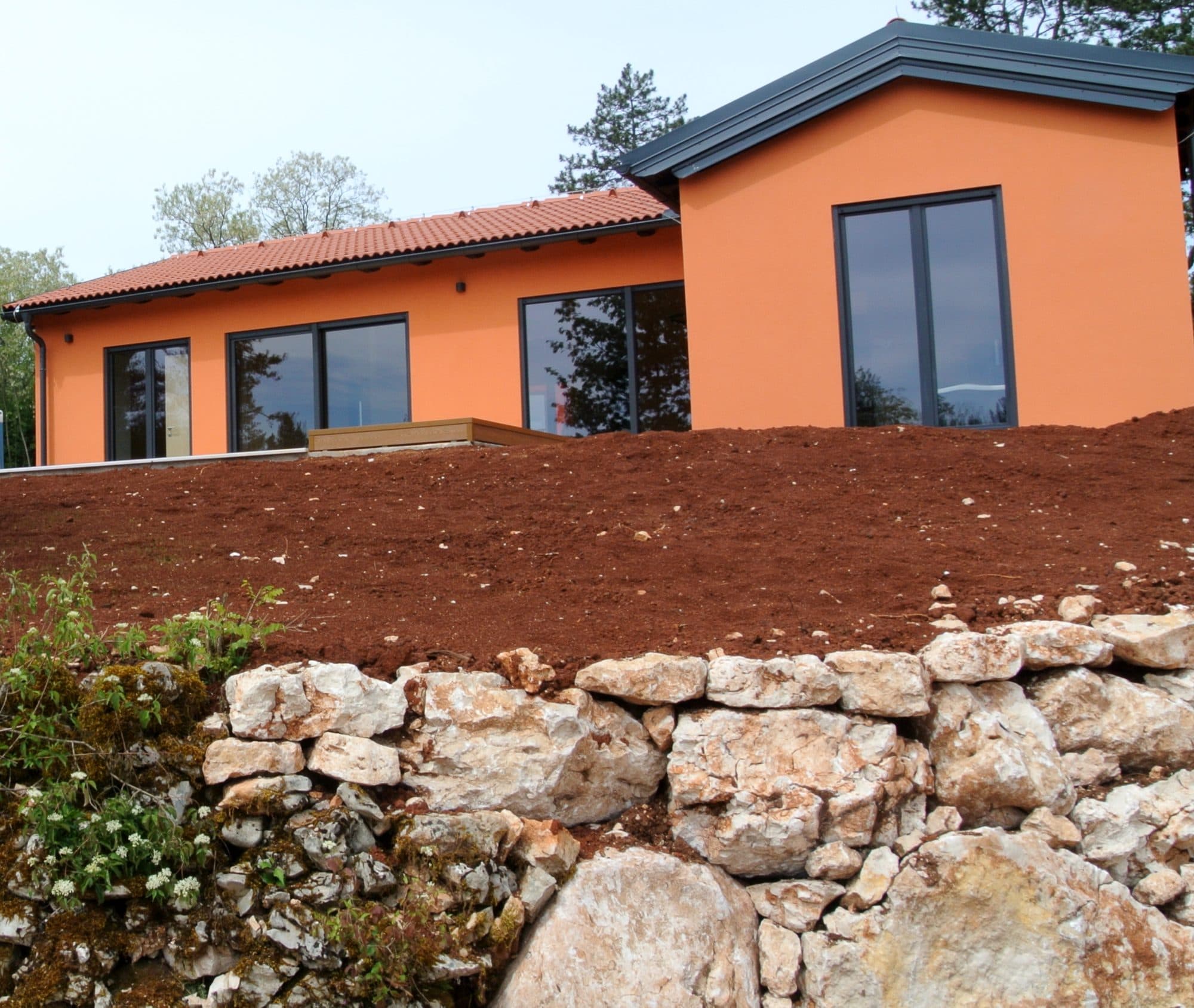 A completed home above an old dry-stone wall